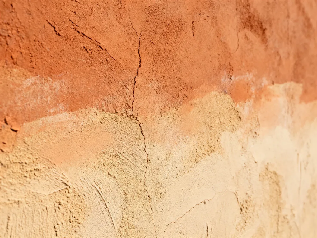 Natural color variation and fine cracks in clay plaster